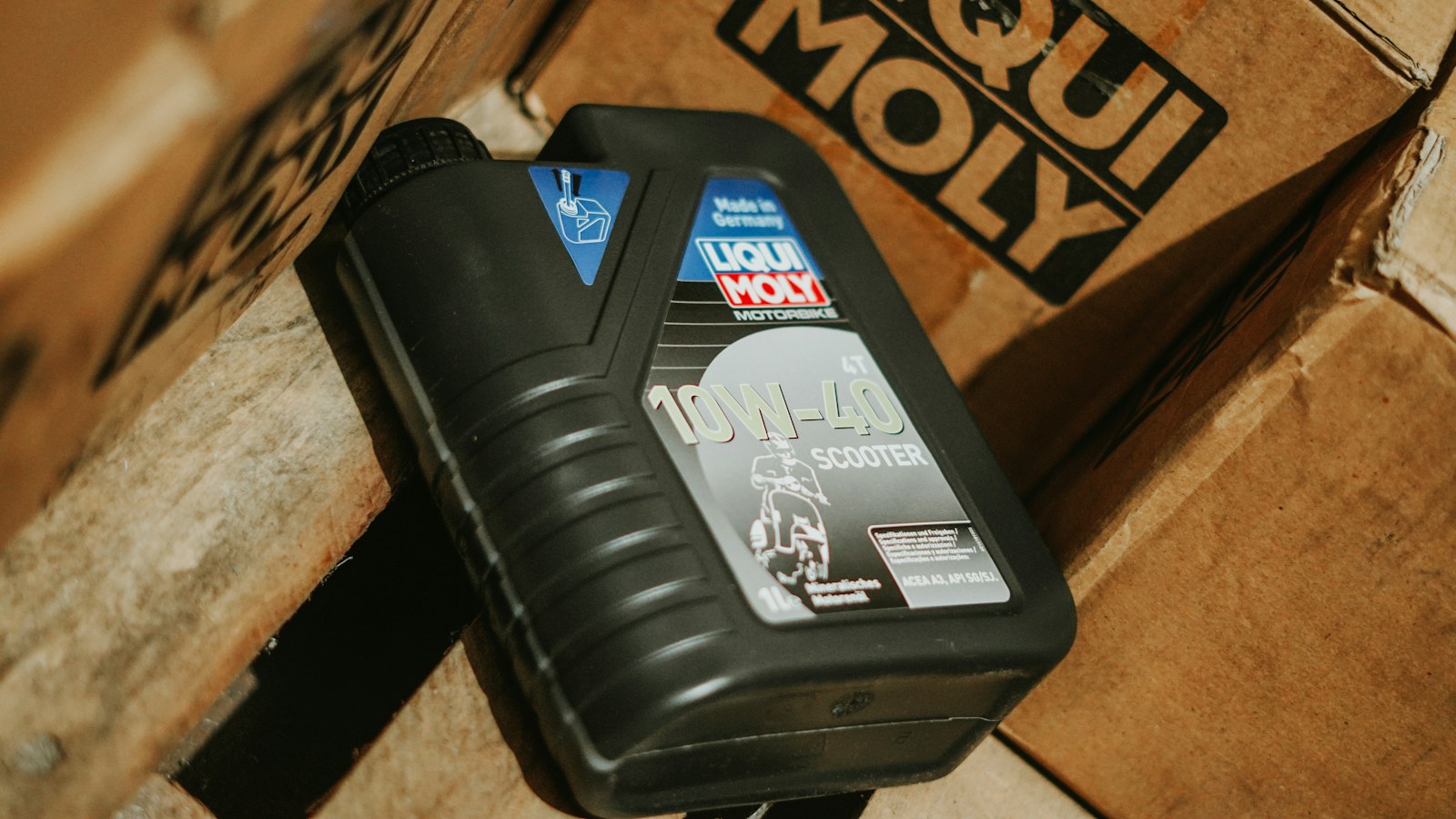 Karton kutular üzerinde duran Liqui Moly motor yağı şişesi